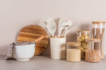 Kitchen background. A set of kitchen utensils and various utensils for cooking on a stone kitchen countertop. Front view. Eco-friendly cuisine.