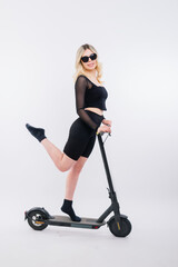Fototapeta na wymiar Happy young woman wear glasses riding electric scooter on background studio People lifestyle concept