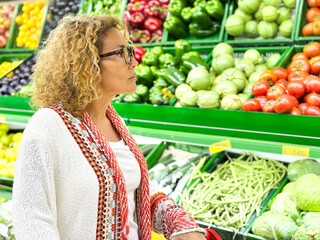 Closeup portrait, beautiful, pretty young woman in sweater picking up, choosing green leafy...