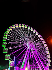 Amusement park at night - ferris wheel in motion. Concept of holiday people and have fun. Nightlife vacation.