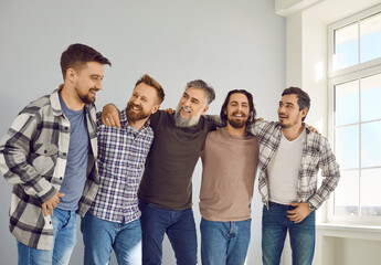 Group of bearded male mature friends looking at each other and smiling having fun at home. Portrait...