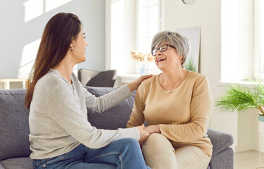 Portrait of a happy smiling adult daughter hugging her senior gray-haired old mother parent resting...