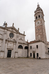 Fototapeta na wymiar Venice church in a square with a large clock tower