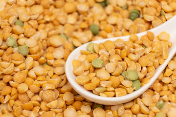 Pea yellow groats grains cereal in spoon close-up macro.