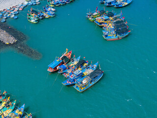 Aerial view of Loc An fishing village, Vung Tau city. A fishing port with tsunami protection concrete blocks. Cityscape and traditional boats in the sea.