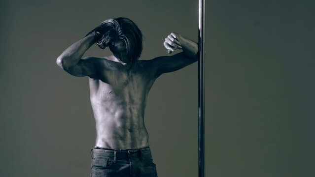 Sexy body of young man. Pole dancer. Sexy man exercise pole dance. Fit slim sexy man performs sensual pole dance. Go-go dancer. Strip dancer. Male athlete doing acrobatic trick on pylon.