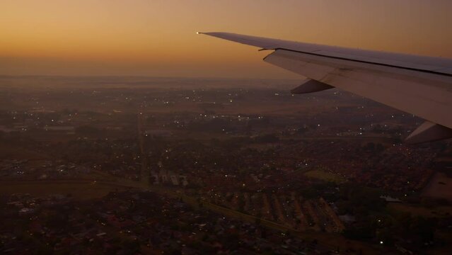 4K footage airplane landing in South Africa . wing of an airplane flying above Johannesburg. beautiful aerial view of from the window of plane on travelling time by aircraft. holiday ,vacation time