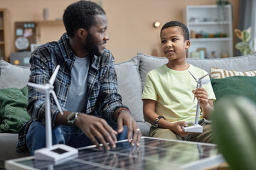Portrait of African American father teaching son on renewable energy sources and solar panels - obrazy, fototapety, plakaty