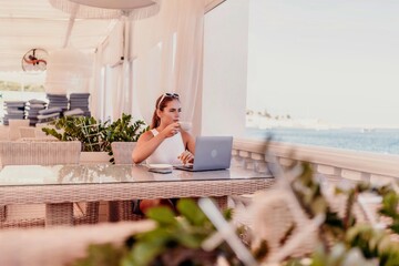 Woman coffee cafe laptop. Woman sitting at a coffee shop with mobile phone drinking coffee and looking away. Caucasian female relaxing at a cafe.