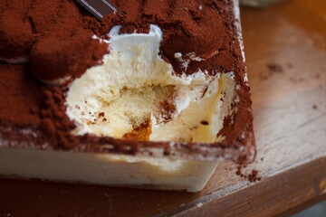 Close-up of tiramisu cake as a textured. Italian no-bake dessert made of savoiardi, filled with...