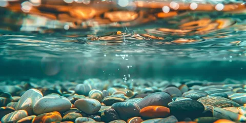 Foto op Plexiglas Smooth multi-colored pebbles are visible beneath clear water in this close-up shot © tashechka