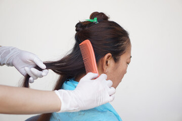 Close up hairdresser is combing hair female client before doing hairstyle. Concept. Woman shouldn't...