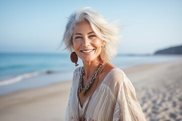 Portrait of a smiling woman wrapped in a blanket on the beach