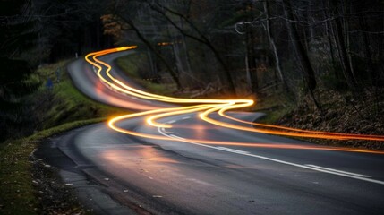 Long exposure shot of vehicles creating light trails on a winding road at night