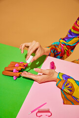 Creative colorful image of woman painting sausage nails against multicolored background, Beauty salon poster. Concept of food pop art photography, creativity, quirky style, surrealism