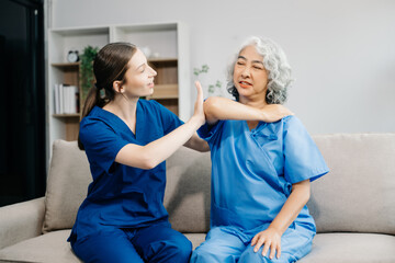 Physiotherapist helping elderly woman patient stretching arm during exercise correct with dumbbell in hand during training hand in hospital . in clinic