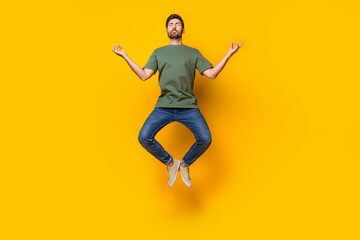 Full length photo of nice young male jump fly meditate stay calm dressed stylish khaki garment isolated on yellow color background