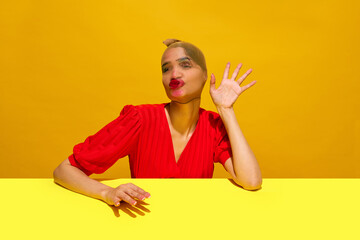 Young woman with stocking over head with smudged lipstick makeup making funny expression against yellow background. Concept of food pop art photography, creativity, quirky style