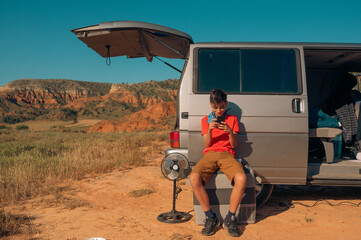 Young boy chatting with smartphone in the van in the red canyon of Teruel, Spain.