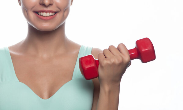 Cropped image of young woman lifting dumbbells against white background