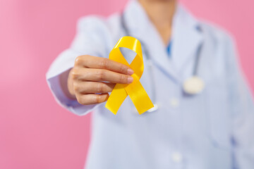 Medical doctor holding yellow ribbon isolated on pink background, Yellow September, Suicide...