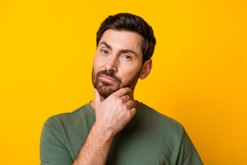 Fototapeta premium Photo of intelligent positive guy dressed green t-shirt hand chin empty space isolated yellow color background