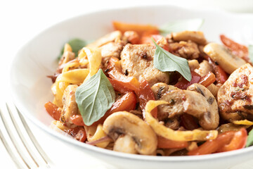 Pappardelle Pasta with chicken breast, red pepper and champignons. Bright background. Close up.	
