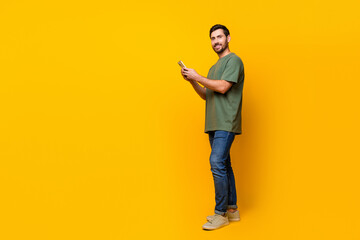 Fototapeta na wymiar Full body photo of handsome young guy instagram twitter facebook telegram wear trendy khaki outfit isolated on yellow color background