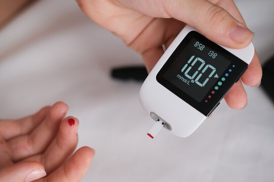 Diabetes checking blood sugar level. Child using lancelet and glucometer at home