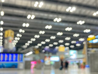 Fototapeta premium blurred photography of the terminal hall at the airport where travellers walk and bokeh of light bulbs on the ceiling