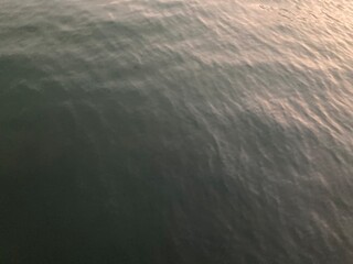 the smooth waves on the black sea surface when the sunset shines above it, using for background