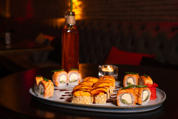 Close-up of delicious mouth-watering baked sushi rolls on the table in the restaurant. Concept of food