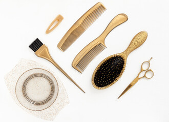 Golden hairdresser tools on white background top view. Hair salon accessories, comb, scissors