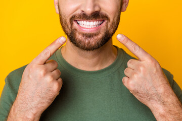Photo of good mood attractive guy dressed green t-shirt showing two fingers white teeth isolated...