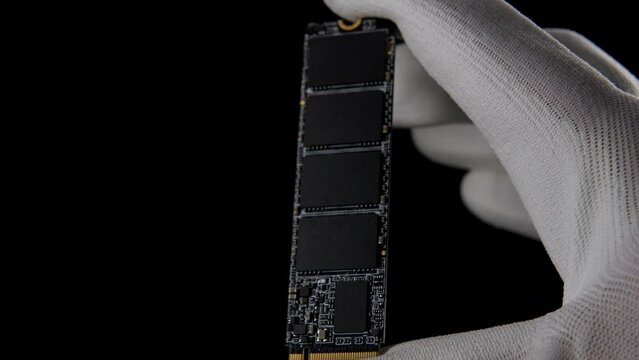In the Darkness: Hand Securely Grasping High-Speed M.2 SSD for PC. High quality photo