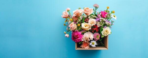 Assortment of colorful flowers in a box on blue background