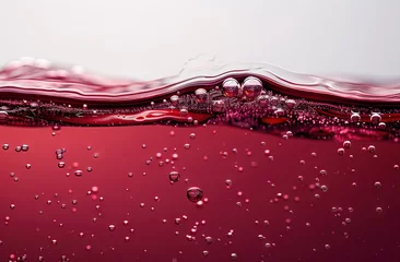 Tuinposter Red wine, bubbles on the surface of the red liquid, closeup of the red juice flowing in a white background © Ирина Малышкина