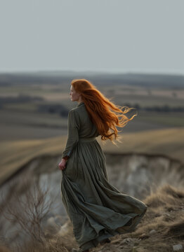 Beauty historical Early american pioneer woman with red hair and dark green dress outdoors. Back view. Old west, Victorian, Georgian, Edwardian. Historical romance. Standing on a cliff. Highlander