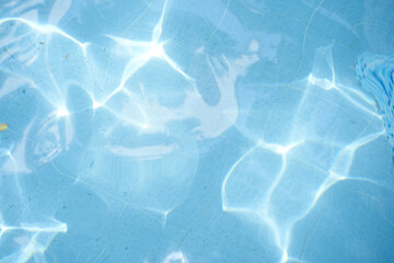 Top view of surface blue swimming pool, reflection on blue water, swirl pattern texture, blue tiles. Leaves in dirty water, opened swimming pool. Background, backdrop with copy space.