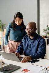 Black Man And Asian Woman Working On Plan