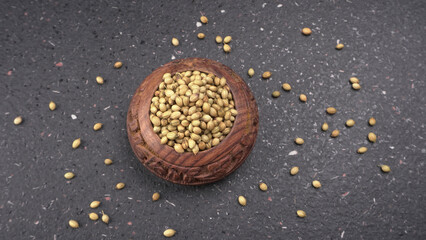 Dried coriander seeds with fresh green leaf isolated on wooden background. Top view. Flat lay