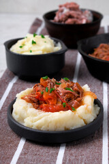 Stewed meat with potato mash served on the plate. Nutritious meal for lunch or dinner