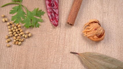 Dried coriander seeds with fresh green leaf isolated on wooden background. Top view. Flat lay