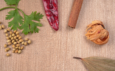 Dried coriander seeds with fresh green leaf isolated on wooden background. Top view. Flat lay