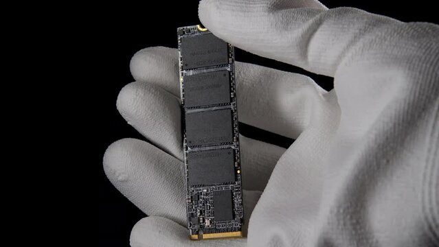 In the Darkness: Hand Securely Grasping High-Speed M.2 SSD for PC. High quality photo