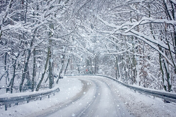 winter landscape road in a snow-covered forest. Snowfall in the forest