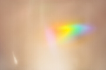 Defocused abstract beige background with rainbow flare from sunlight, holiday backdrop, celebration wallpaper. Colorful sparkle sun glare, Glittering aesthetic textured photo pattern, trend color