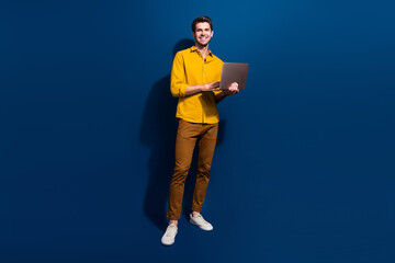 Full length photo of nice young male hold netbook work remotely dressed stylish yellow garment...