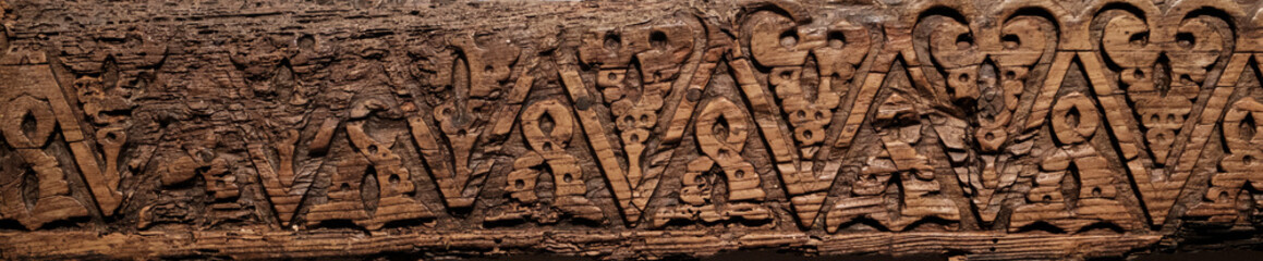 Antique wooden fragment with detailed, geometric carvings, a piece from historic furniture or...