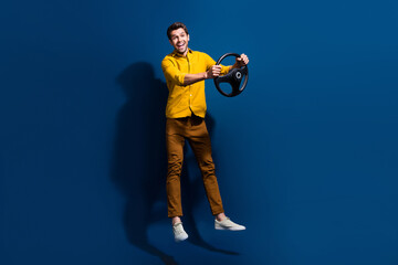 Full size photo of handsome young man jump hold steering wheel driving wear trendy yellow outfit...